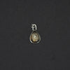 Citrine floral drop intaglio charm hanging front-on against black, the whole charm small in frame and the flower centred in the drop