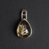 Citrine floral drop intaglio charm - a floral charm, a single flower on a leafy stem reverse-carved into a pear-shaped honey-gold citrine, in a plain silver bezel with a long loop bale