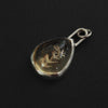 Citrine floral drop intaglio charm from behind, the hollow back left open so light can pass through the gem, the carving visible in reverse
