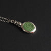Field mouse intaglio necklace angled the other way, the chain to the left, the foliage carving filling the oval and the silver bezel bright around it