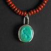 turquoise intaglio cat necklace on red jasper - a cat necklace, a stylised cat seated in profile with its tail curled, hand-carved into a green turquoise oval
