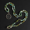 quartz and chrysoprase seaweed intaglio necklace coiled on black, pale green chrysoprase teardrops running the full length of the strand to a bolt-ring clasp