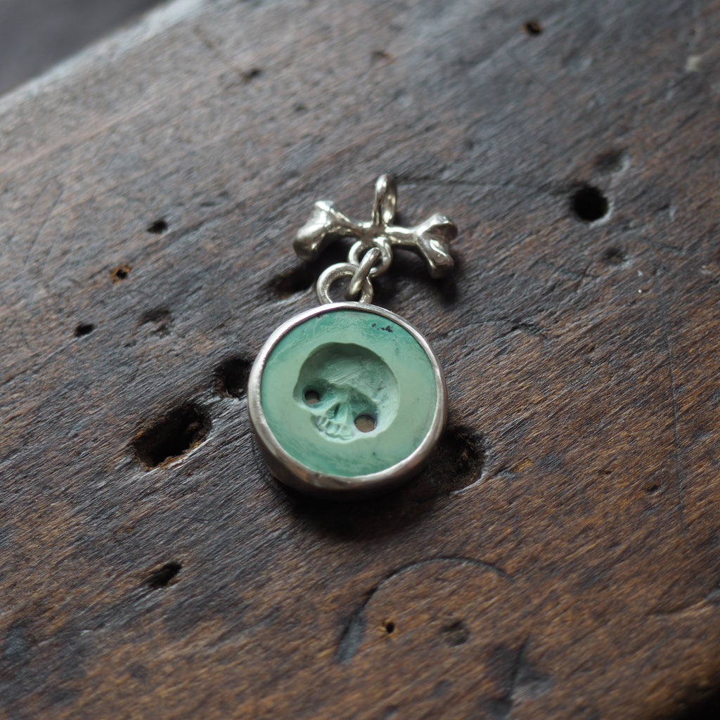 Hollow-eyed skull turquoise intaglio charm