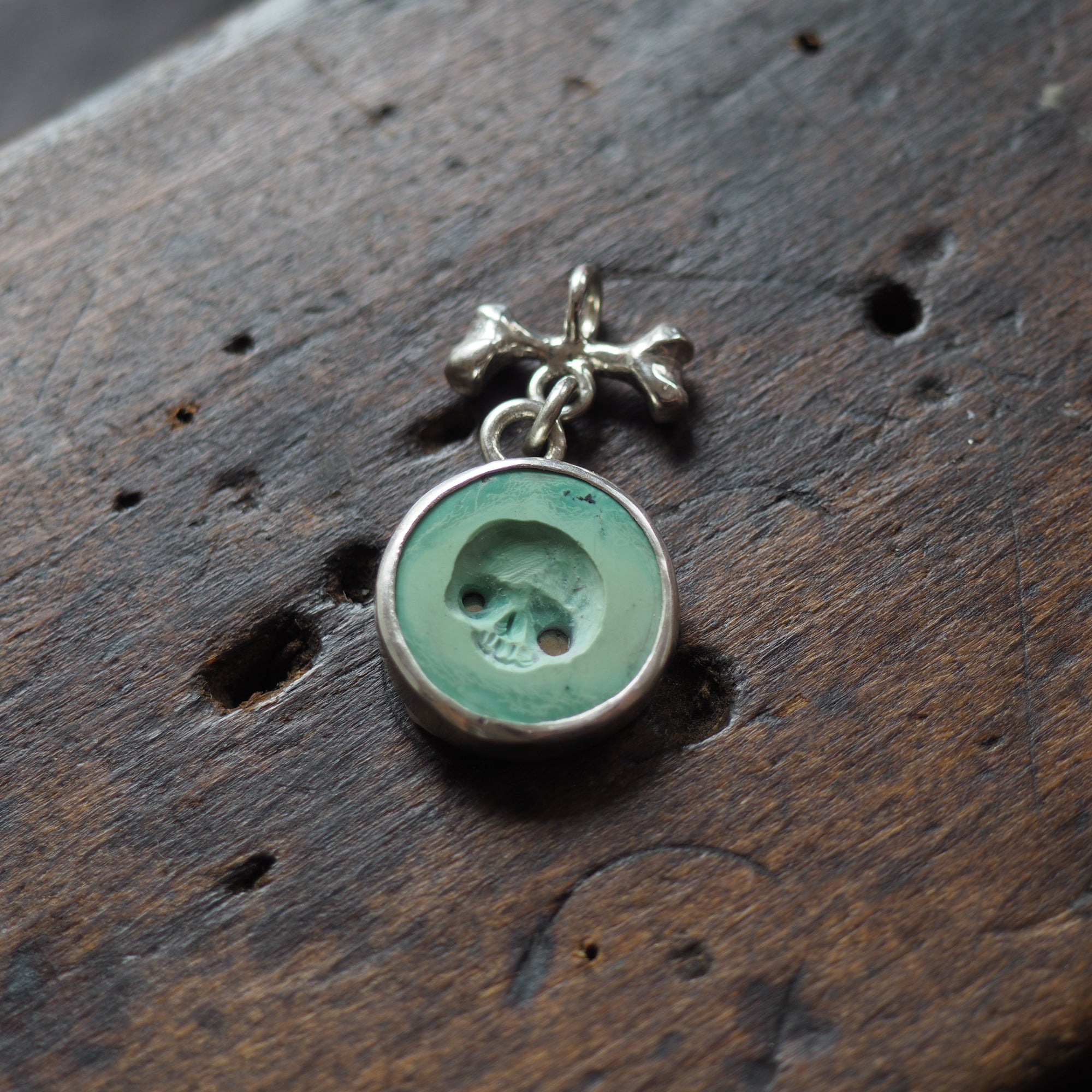 Hollow-eyed skull turquoise intaglio charm