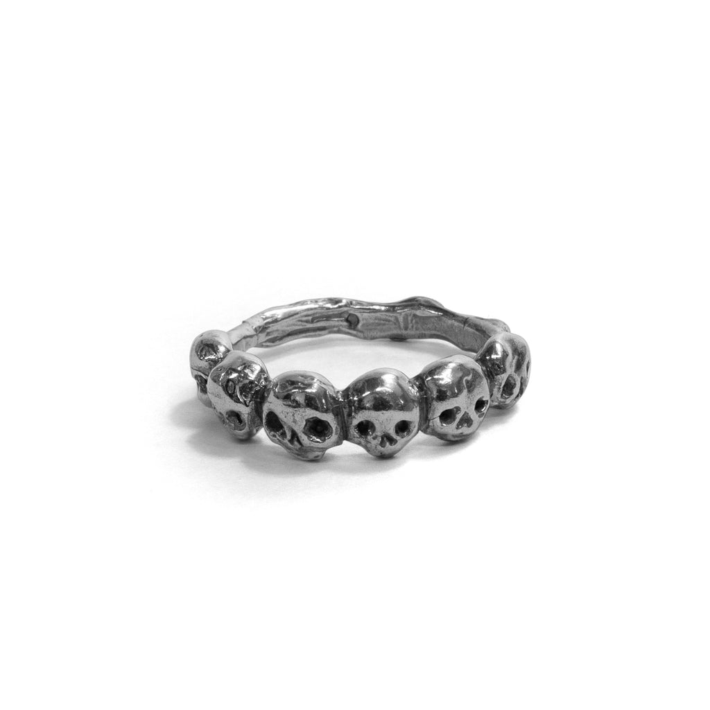 Front view of the sterling silver micro skull band ring showing the full row of sculpted skulls.