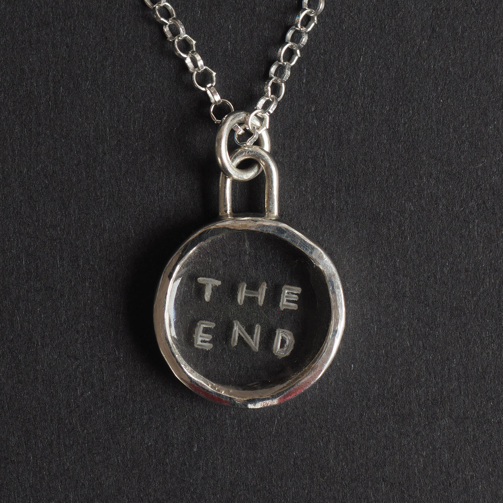 The End Quartz reverse intaglio necklace - an unusual necklace, the words THE END hand-cut in two lines into a small disc of clear rock crystal, in a plain silver bezel