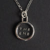 The End Quartz reverse intaglio necklace - an unusual necklace, the words THE END hand-cut in two lines into a small disc of clear rock crystal, in a plain silver bezel
