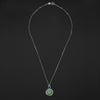 Turquoise Skeletal Torso intaglio necklace laid out full length on black, the clasp at the top and the round turquoise pendant at the foot of the chain