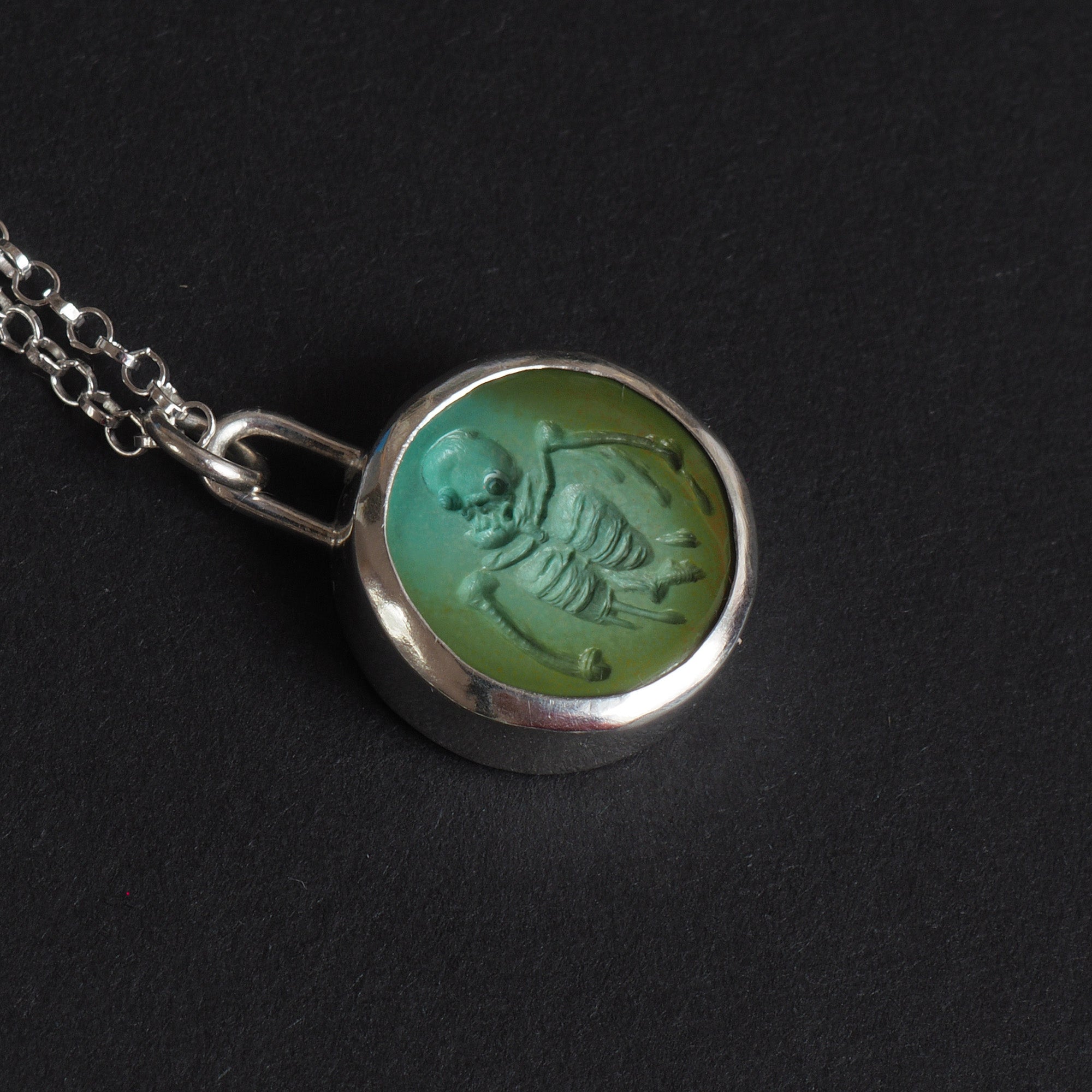 Turquoise Skeletal Torso intaglio necklace - a skeleton necklace, a skull and ribcage cut deep into a round slice of Tibetan turquoise, the bones seeming to slump and run
