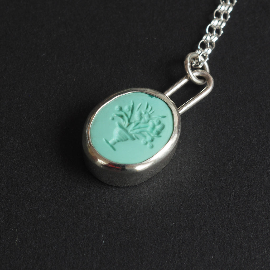 Turquoise Vase of Flowers intaglio necklace - a vase necklace, a footed vase holding a spray of flowers and leaves, hand-carved into a mint-green turquoise oval