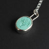 Turquoise Vase of Flowers intaglio necklace - a vase necklace, a footed vase holding a spray of flowers and leaves, hand-carved into a mint-green turquoise oval